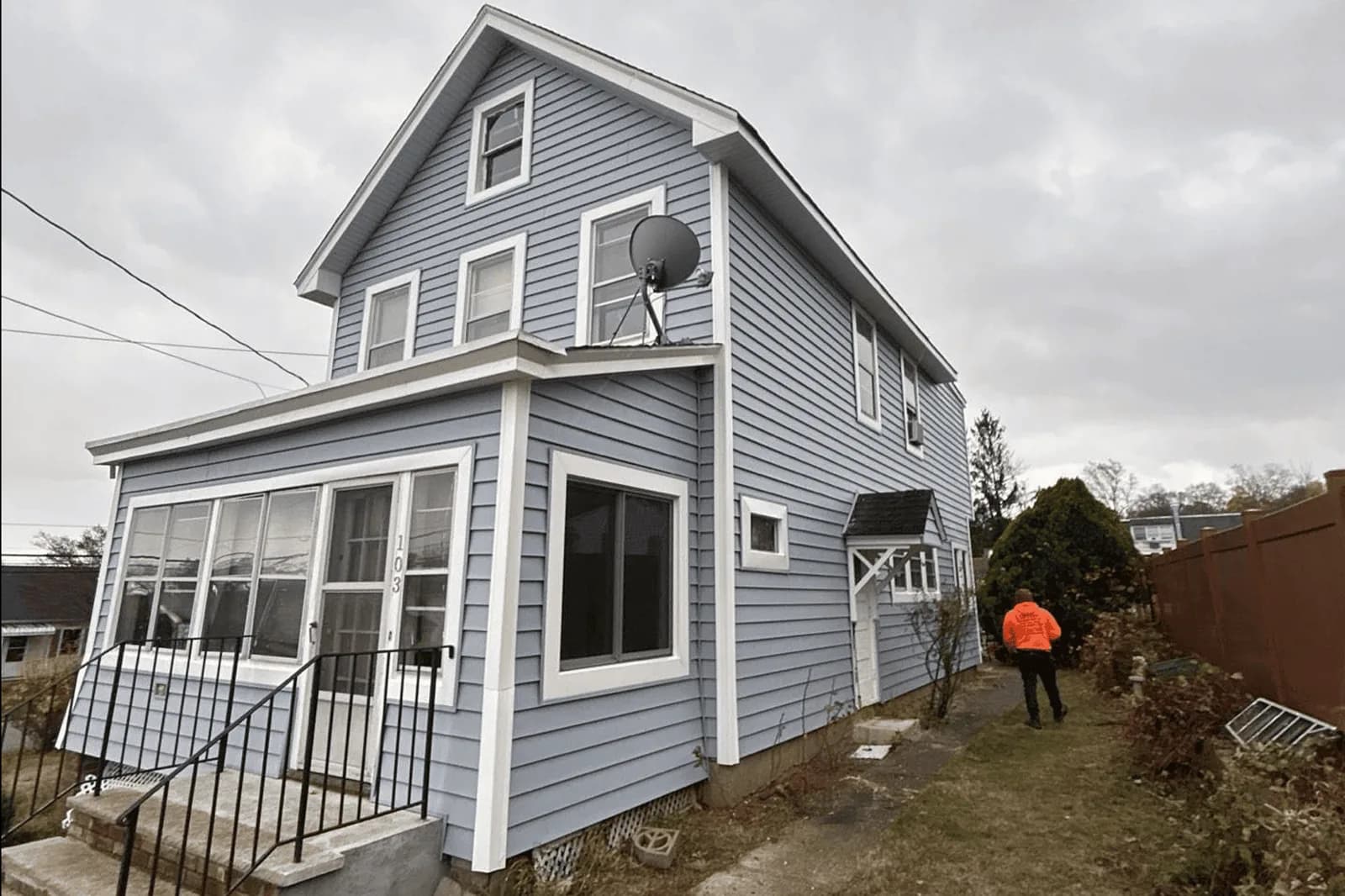 Vesta exterior renovation with gray siding, white window trim and an enclosed porch